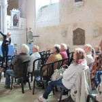 Le public installé dans la chapelle de l'église, face au retable